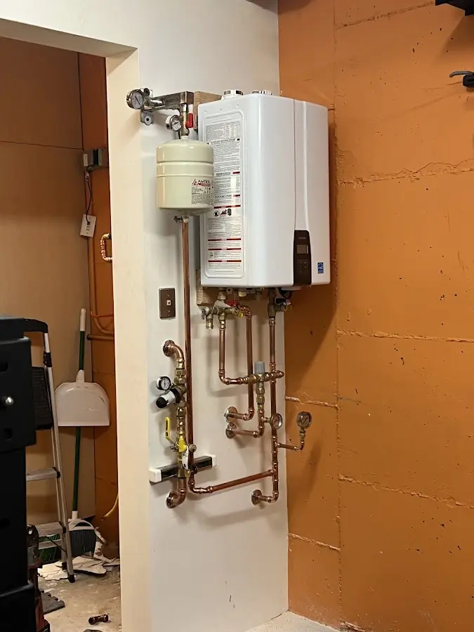 Plumbing technician inspecting water heater connections in Salem